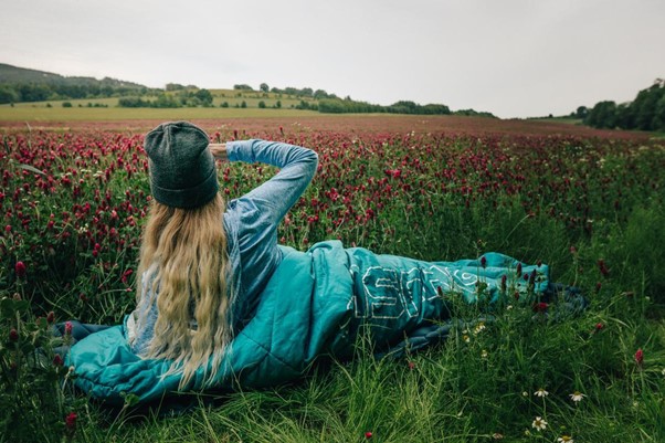 Už víš, co od spacáku očekáváš? Dívka ve spacáku v makovém poli